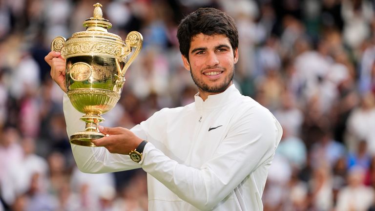 Spain's Carlos Alcaraz celebrates with the trophy after beating Serbia's Novak Djokovic to win the final of the men's singles on day fourteen of the Wimbledon tennis championships in London, Sunday, July 16, 2023. (AP Photo/Kirsty Wigglesworth)