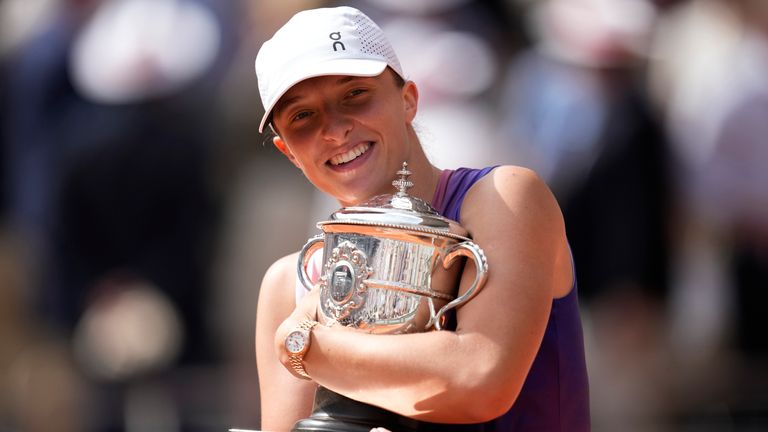 Poland's Iga Swiatek celebrates with the trophy as she won the women's final of the French Open tennis tournament against Italy's Jasmine Paolini at the Roland Garros stadium in Paris, France, Saturday, June 8, 2024. (AP Photo/Christophe Ena)