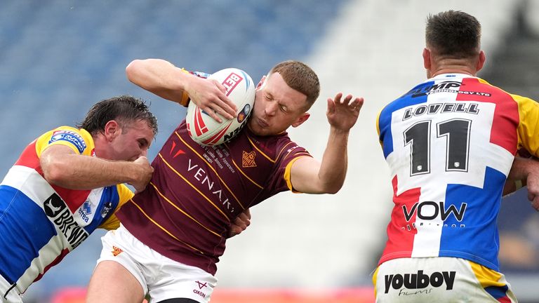 Huddersfield Giants' Oliver Russell (centre) tackled by London Broncos' Jack Campagnolo during the first half 