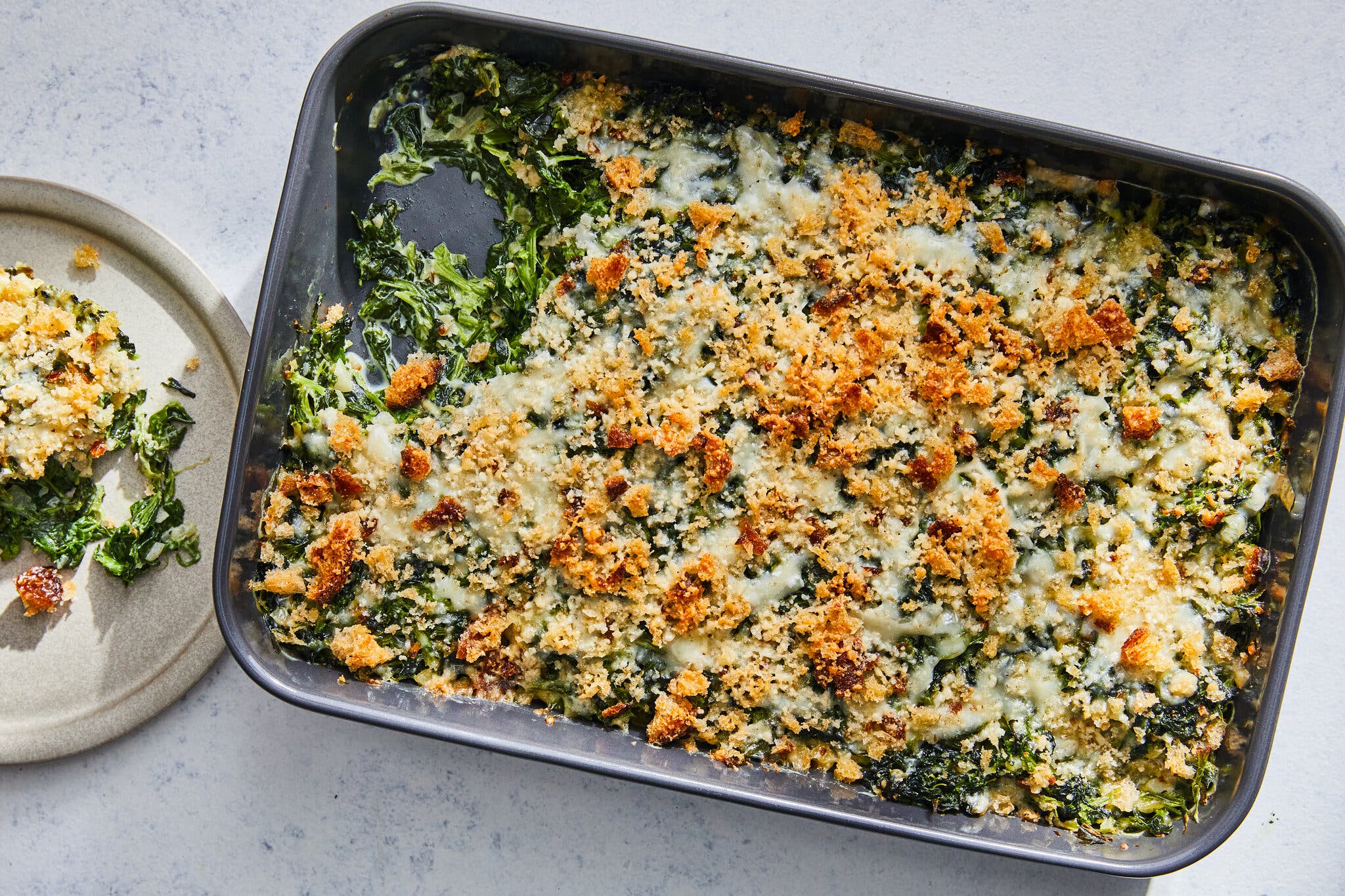 An overhead image of a cheesy spinach bake topped with bread crumbs.